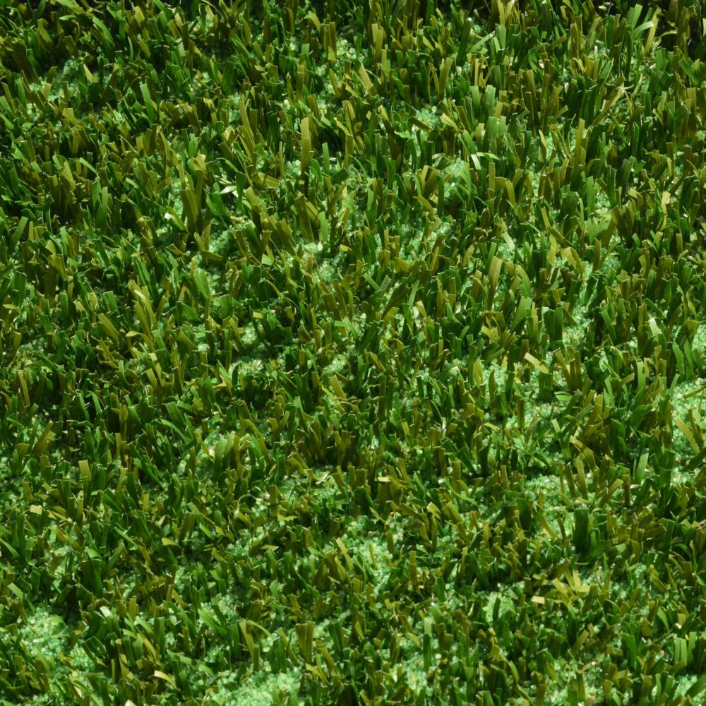 A close up shot of artificial turf designed for playgrounds featuring short green and brown grass strands